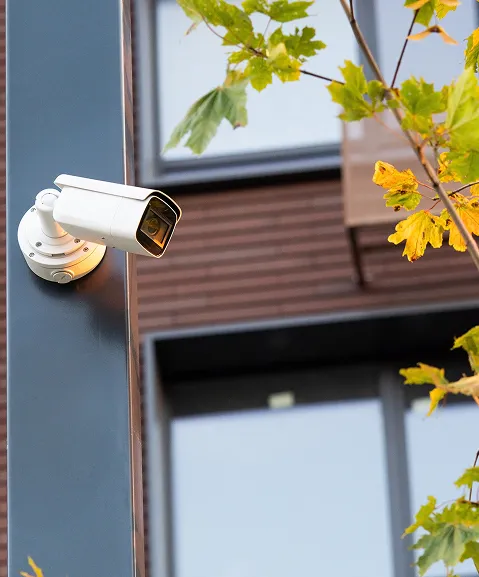 Caméra de surveillance extérieure fixée au mur d’une maison, près d’une fenêtre